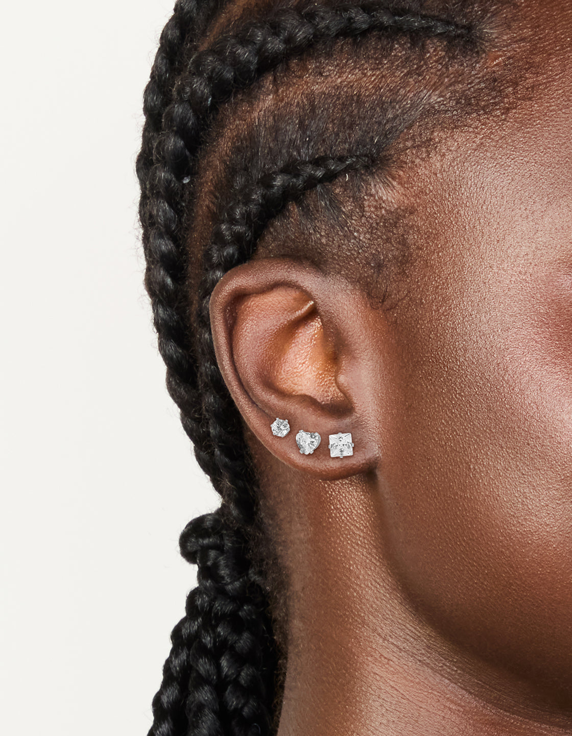 Showcasing waterproof stainless steel mixed stud earrings in a 3-pack featuring round cut cubic zirconia stones with silver and clear tones on ear view