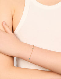 Showcasing a gold plated bracelet featuring blue teardrop cubic zirconia with dainty chain and adjustable closure on wrist view - link has visual effect only